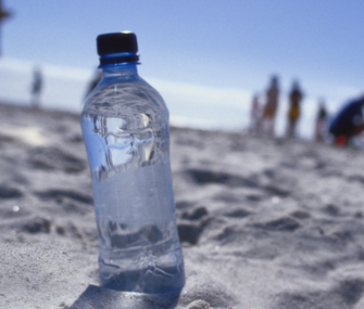 Close-up of a bottle of water on the beach